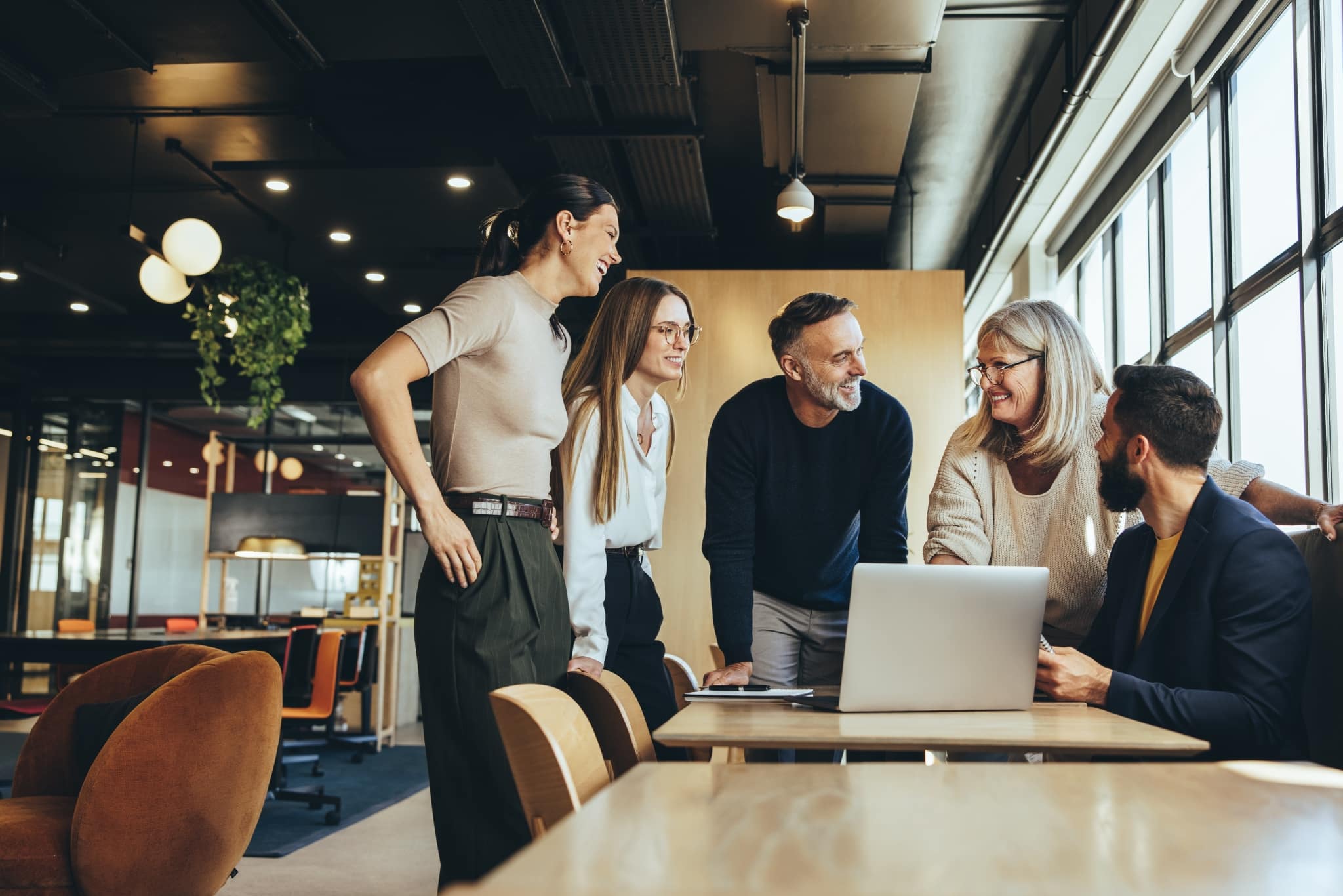 In the image, finance professionals are discussing at a computer. Check out our open careers and become part of our growing and international organization.
